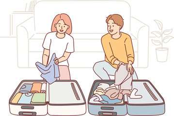 Man and woman are collecting baggage preparing to go on trip and kneeling near travel suitcases