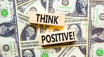 Think positive symbol. Concept words Think positive on beautiful wooden block. Beautiful background from dollar bills. Dollar bills. Business, motivational think positive thinking concept. Copy space.