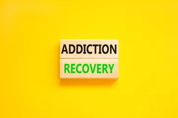 Poster Addiction recovery symbol. Concept words Addiction recovery on beautiful wooden blocks. Beautiful yellow table yellow background. Psychology addiction recovery concept. Copy space. © Dzmitry