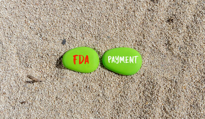 Fototapeta na wymiar FDA Food and Drug Administration payment symbol. Concept words FDA payment on beautiful green stone. Beautiful sand beach background. Business FDA payment concept. Copy space.