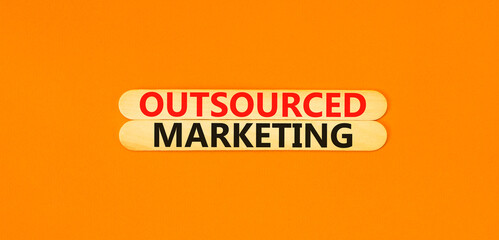 Outsourced marketing symbol. Concept words Outsourced marketing on beautiful wooden stick....