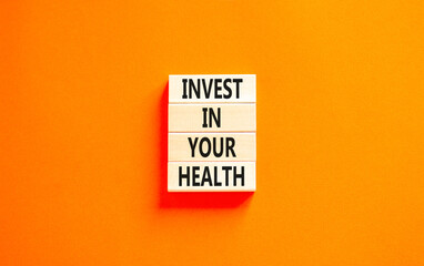 Invest in your health symbol. Concept word Invest in your health on beautiful wooden block. Beautiful orange table orange background. Invest in your health concept. Copy space.