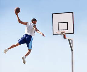 Man, basketball and dunk jump on outdoor court for scoring point, game challenge or athlete. Male person, hand and hoop strong for exercise fun or fitness training in summer, player for winner match