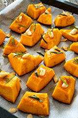 Uncooked pumpkin with rosemary and garlic on wooden table