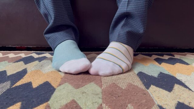 men's feet in different socks as a symbol of down syndrome day.