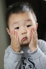 A child's face witnessing an unbelievable moment. Asian boy's face reflects despair, saying 