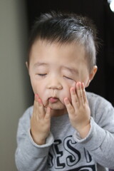 A child's face reflects despair, disbelief and a plea for cessation. Asian boy's face reflects disbelief and saying "That's enough, please stop" inside his head.
