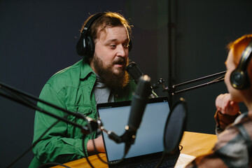 Radio presenters communicate live. The presenter and his guest have a conversation during the broadcast.