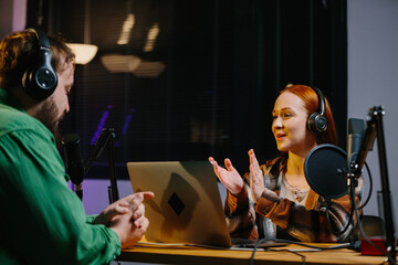 Man having conversation with woman in internet broadcast using professional microphone and audio...