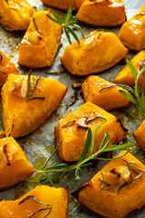 Roasted pumpkin with rosemary and garlic on wooden table