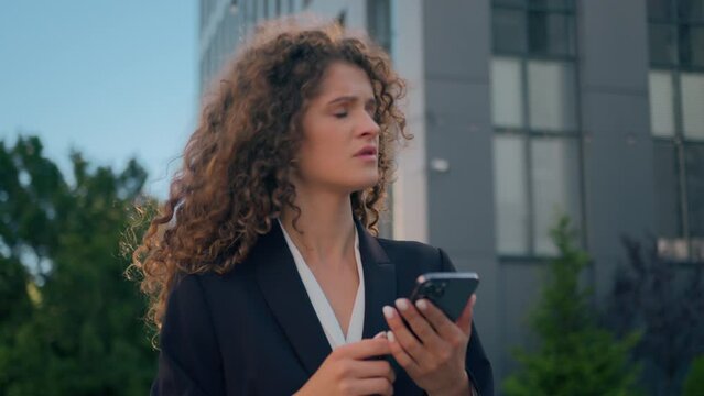 Confused business woman walk in city looking around outdoors search geolocation on mobile phone online map Caucasian businesswoman girl using smartphone app outside look for taxi explore urban town