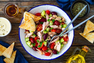 Tuna greek salad on wooden table
