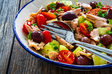 Tuna greek salad on wooden table
