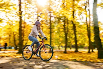 Rolgordijnen Motion Blur.  Woman riding bicycle in city park © Jacek Chabraszewski