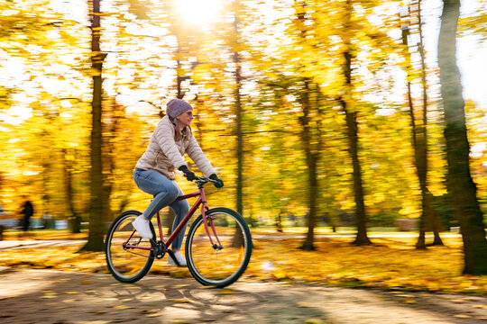 Motion Blur.  Woman riding bicycle in city park