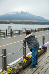 Rear of young Asian boy at lake yamanakako look at mount Fuji