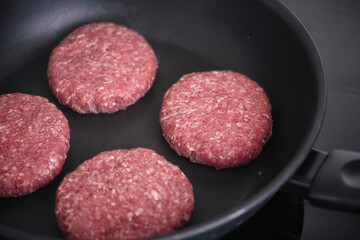Beef patties cooking in a pan. Close up.