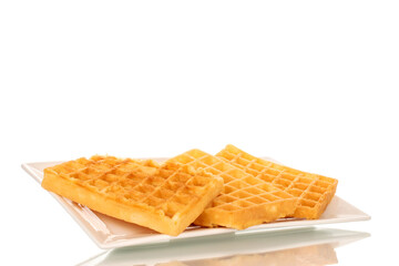 Three freshly baked aromatic waffles on a ceramic white plate, macro, isolated on a white background.