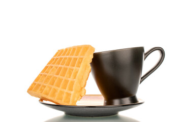 One freshly baked aromatic waffle with ceramic saucer and cup, macro, isolated on white background.