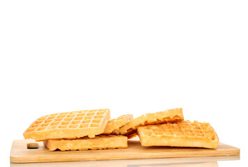 Several freshly baked aromatic waffles on a bamboo kitchen board, macro, isolated on white background.