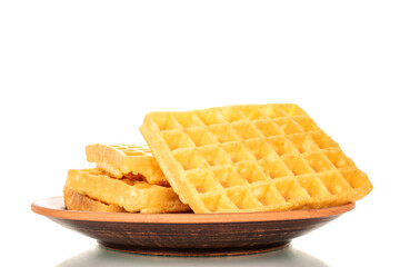 Several freshly baked aromatic waffles on a clay plate, macro, isolated on white background.