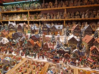 Handcrafted ornaments, snow globes, and wooden houses in Salzburg Christmas market store. European...