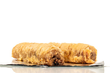 Two pieces of sweet baklava on foil, macro, isolated on white background.