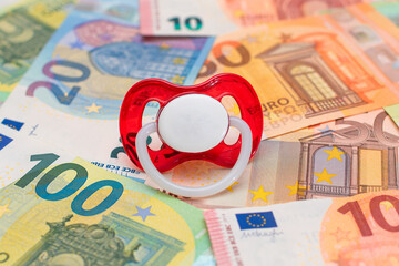 Childfree, Contraception and Birth Control Concept: Baby Pacifier on the Euro Banknotes. Having...