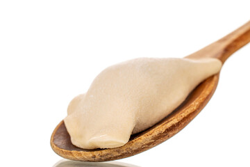 One frozen semi-finished dumpling with wooden spoon, macro, isolated on white background.