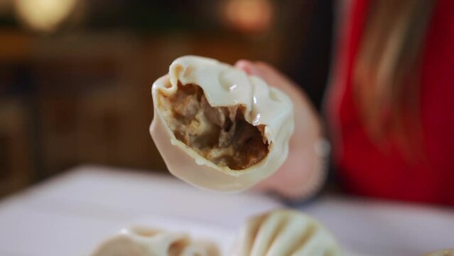 person bite khinkali dumpling with meat or mushrooms