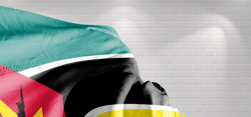 Mozambique national flag cloth fabric waving on beautiful light Background.