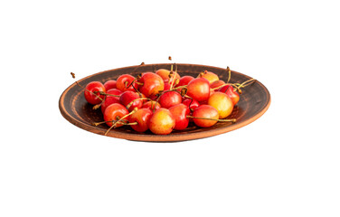 Several sweet cherry berries on a clay plate, macro, isolated on white background.