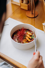 Close up of woman eating Thai food of pumpkin porridge with shrimps in restaurant