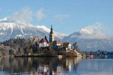 Fototapeten A church on an island on a lake in Bled, Slovenia. Winter. © Mayava