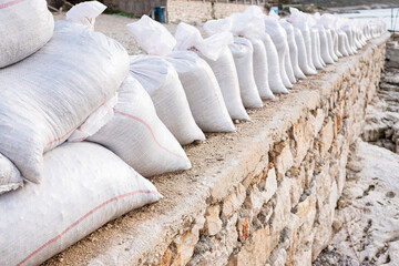 Fototapeta na wymiar White sandbag bags are full with sand in wall formation and ready for defense.