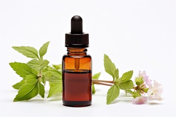 A bottle of essential oil next to a flower. Dark glass bottle on white background.