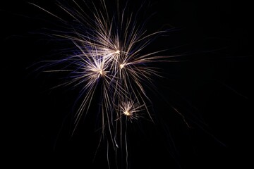 Gold and bluish fireworks isolated on a black background.