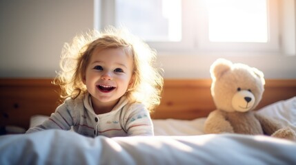 A little girl with a joyful smile lying on her bed.