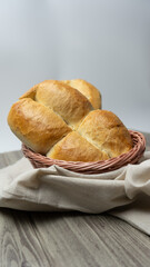 Traditional Chilean Marraqueta bread, in a bread basket with white background on gray wooden table.