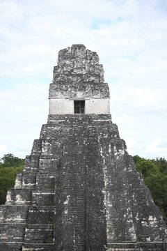 Vertical shot of Tikal Temple I under blue bright sky