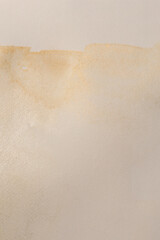 Gold glitter watercolor grain blot on beige paper texture background..