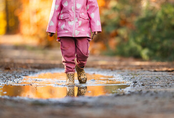 little girl playing in the mud during autumn