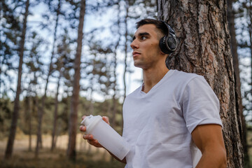athlete man caucasian male hold supplement shaker outdoor