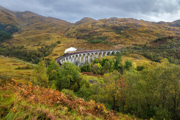 Steam train at the viaduct of Glenfinnan, also known as the Harry Potter train and Harry Potter viaduct.