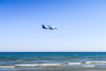 Fototapeta na wymiar the plane lands over the sea, the beach. The plane flies over the beach umbrellas