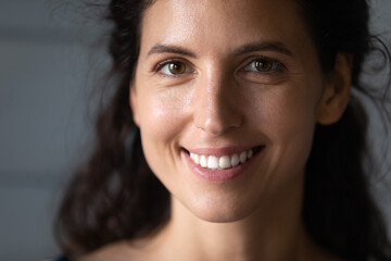 Head shot close up of beautiful smiling woman with smooth perfect skin and healthy toothy smile,...