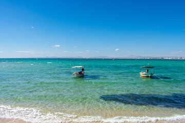 Fototapeta na wymiar Hammamet Tunisia, Beach and boats on shallow water, view on Mediterranean sea 
