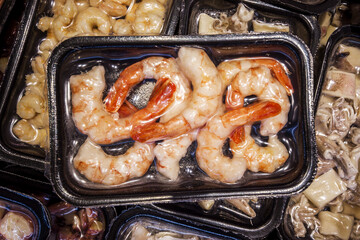 Shrimp tails in vacuum trays sealed for sous vide cooking for sale in supermarket refrigerated...