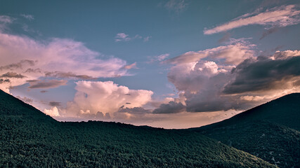 Un coucher de soleil époustouflant, teintant le ciel en nuances éblouissantes d'orange et de magenta. Le Mont Ventoux se dresse fièrement à l'horizon, baigné dans une lumière chaude et dorée. Les peti