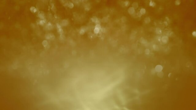 Abstract golden orange sparkling water bokeh glitter mock-up loop background. Concept 3D animation for luxury showcase product packshot backplate. Elegant Festive holiday season backdrop template.